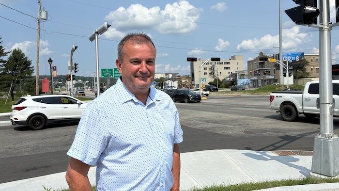 Un homme qui pose devant une intersection.