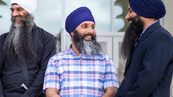 Hardeep Singh Nijjar en turban discute avec deux autres personnes le 2 juillet 2019. 