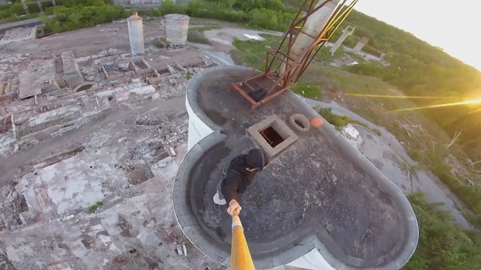 Une personne se tient sur le toit d'un silo des ruines de l'usine Belgo à Shawinigan. 