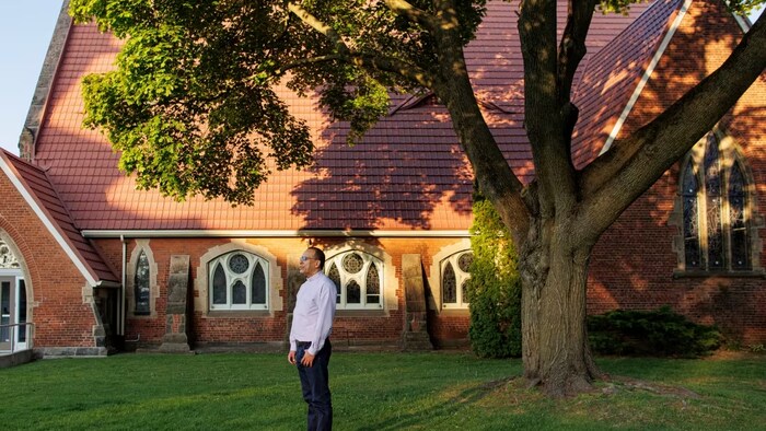 Deacon Enrique Martinez stands outside the Trinity Anglican Church, where twice a week he welcomes migrant workers for a social gathering. (Evan Mitsui/CBC)