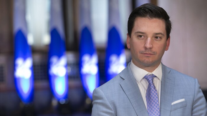 M. Jolin-Barrette devant des drapeaux du Québec.