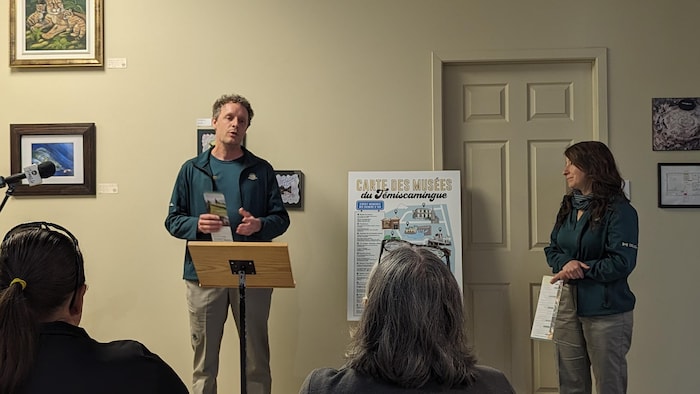 A man and a woman give a presentation to seated people.