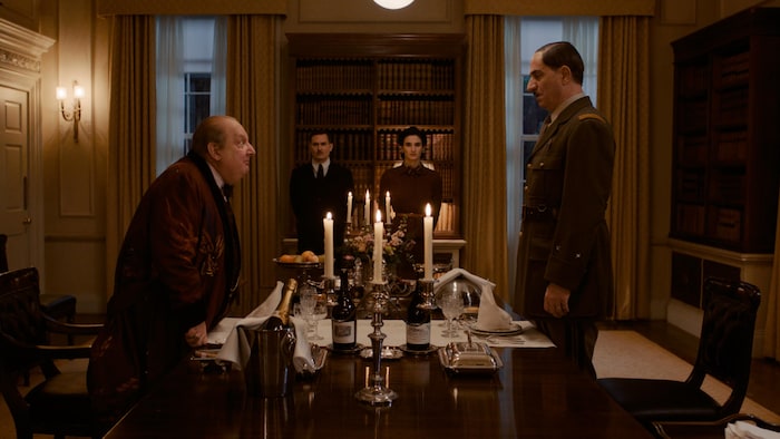 Les acteurs incarnant Winston Churchill et Charles de Gaulle se font face autour d'une longue table avec deux hommes à son bout. 