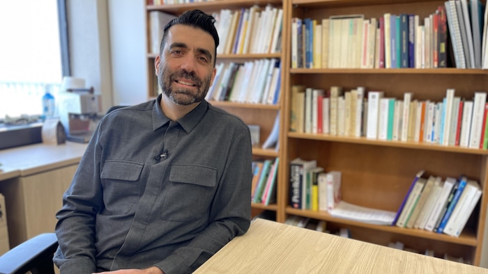 Simon Viviers devant sa bibliothèque.