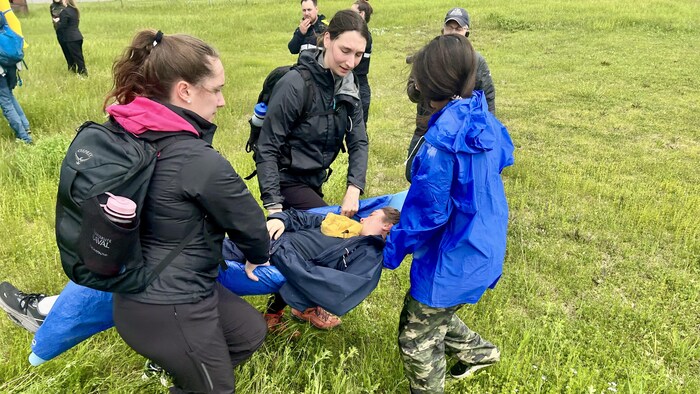 Des étudiantes extirpent une victime de l'autobus.