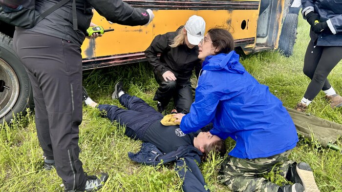 Des étudiantes prodiguent des premiers soins à une victime fictive.