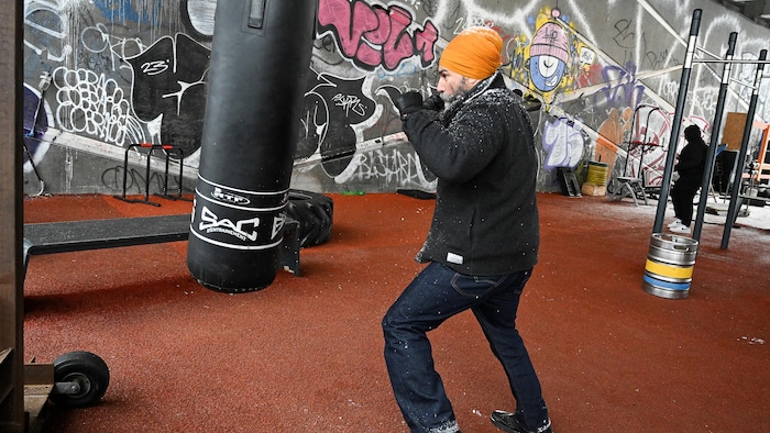 Le cook  du Nouveau Parti démocratique (NPD), Jagmeet Singh, frappe un sac lourd à la suite d'une annonce le deuxième jour de sa tournée de campagne électorale au bassin Peel à Montréal, Québec, Canada le 24 mars 2025. 