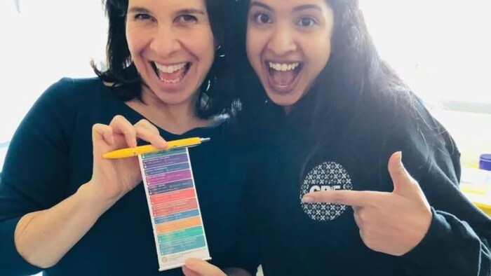 Sinthusha stands beside Montreal Mayor Valérie Plante. Plante is holding one of Divinart's special pens that contains resources for women experiencing conjugal violence.