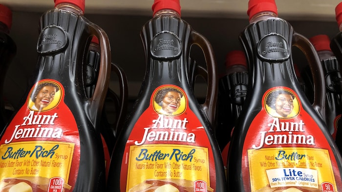 Des bouteilles de sirop Aunt Jemima sur un rayon d'épicerie.