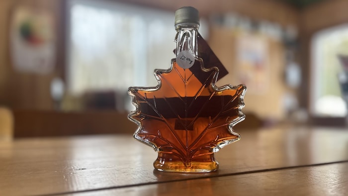 Un petit pot de sirop d'érable de l'érablière des Écorchis en forme de feuille dérable .