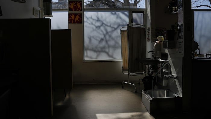 Une salle sombre avec deux cubicules et du matériel médical.