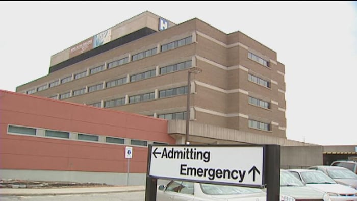 Édifice du site Finch de l’hôpital Humber River, avec, au premier plan, une affiche indiquant l’entrée des patients et l’urgence.