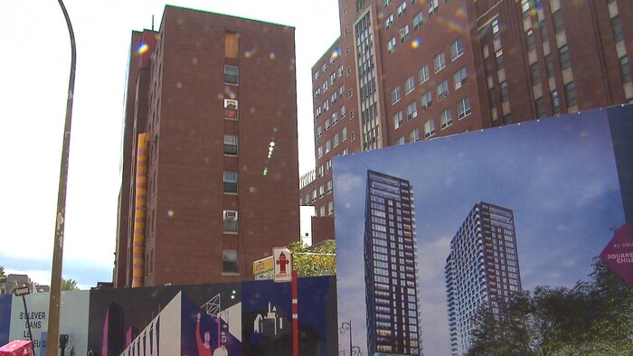 L'ancien site de l'Hôpital de Montréal pour enfants, au centre-ville de Montréal, avec des affiches annonçant le projet immobilier qui doit y être construit.