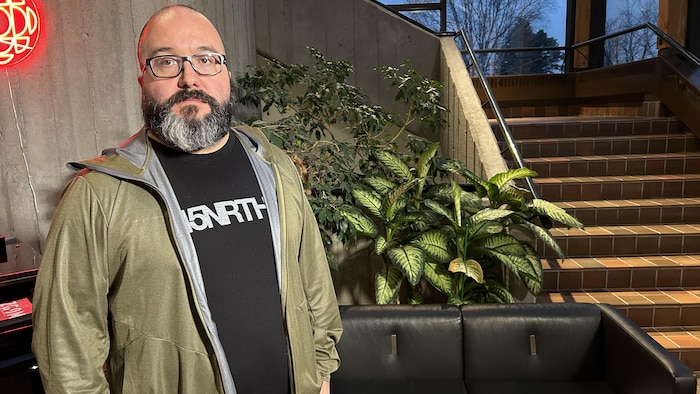 Frédéric Gagnon se tient devant un escalier.