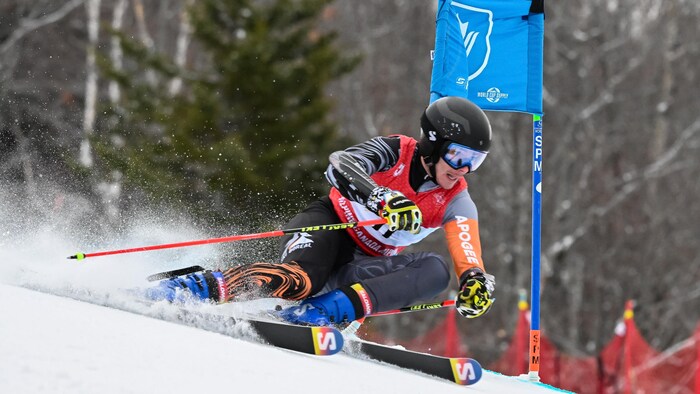 Un skieur contourne une porte lors d'une descente.