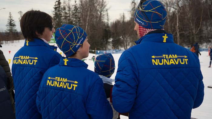 Shannon Chartré regarde la course avec deux athlètes de son équipe du Nunavut, aux Jeux d'hiver de l'Arctique 2024, à Mat-Su en Alaska. 