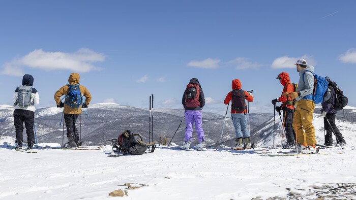 Un groupe de skieur observe la vue au sommet du mont Hog's Back.