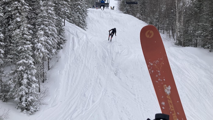 Un skieur descend une pente enneigée au Mont-Édouard.