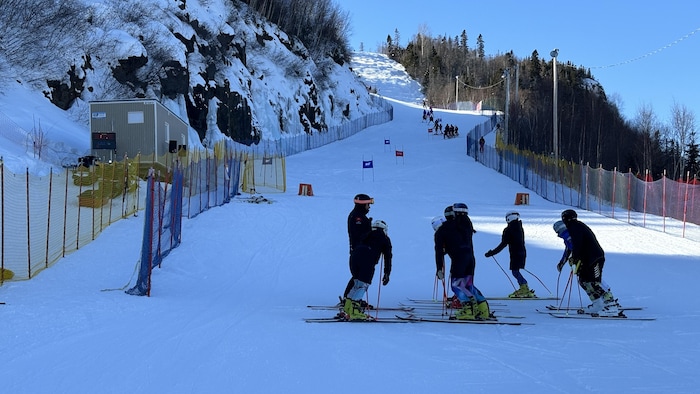 Une piste de ski dans laquelle se trouvent des skieurs.
