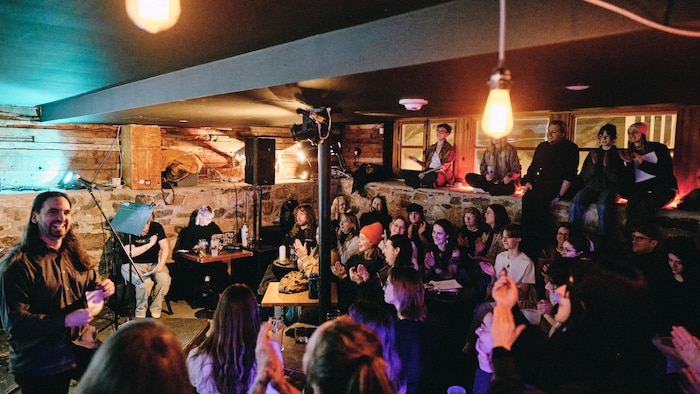 Une foule assise devant une scène