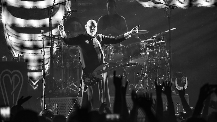 Billy Corgan debout sur une scène devant un batteur.