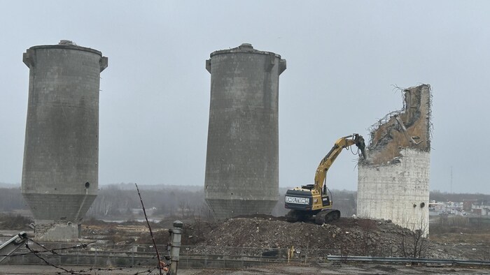 Trois hautes structures en béton, dont l'une à moitié démolie.