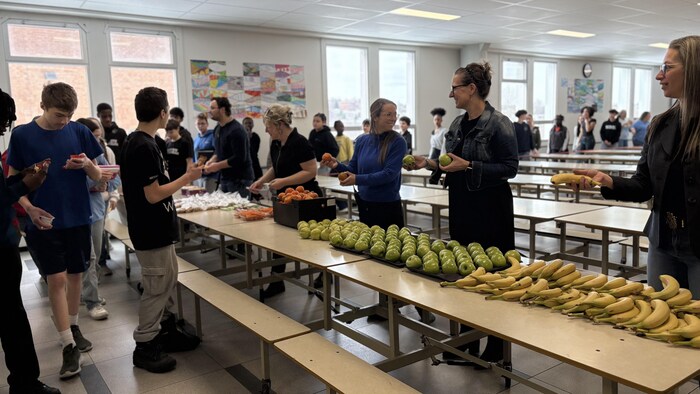 Le personnel enseignant donne des fruits aux élèves.