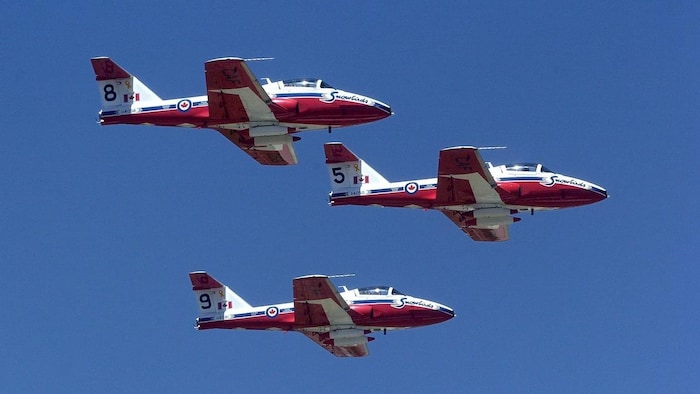 Trois avions Snowbirds dans le ciel.