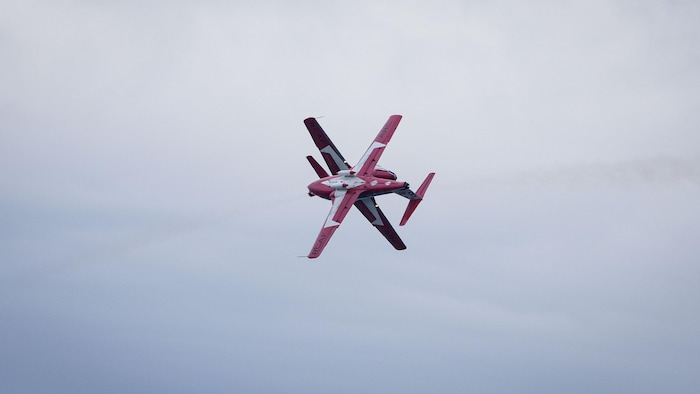 Deux avions des Snowbirds s'entrecroisent dans le ciel.