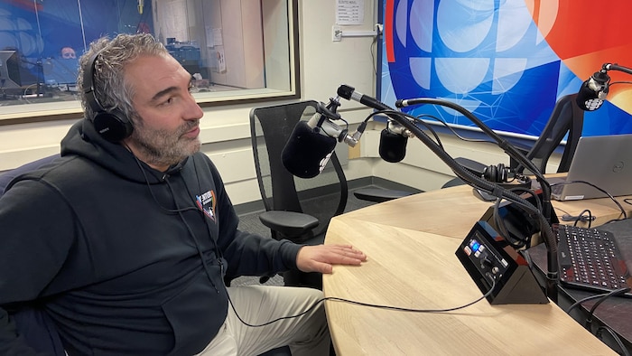 Un homme parle dans un studio de radio.