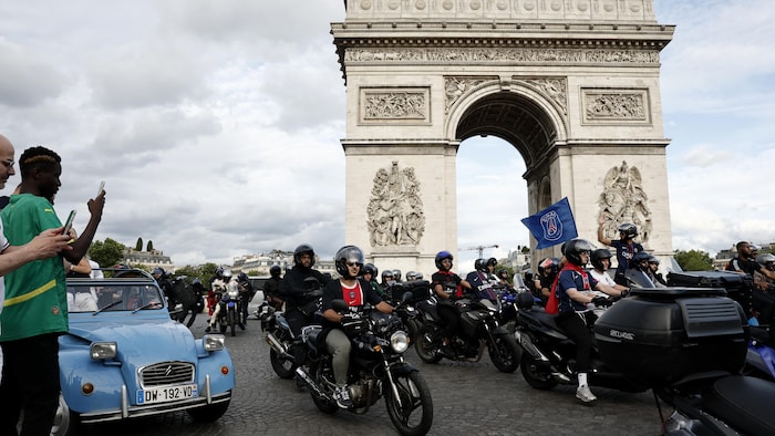 Des partisans du Paris Saint-Germain passent devant l'Arc de triomphe.
