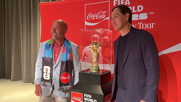 Deux hommes aux côtés du trophée original de la FIFA, à Halifax.