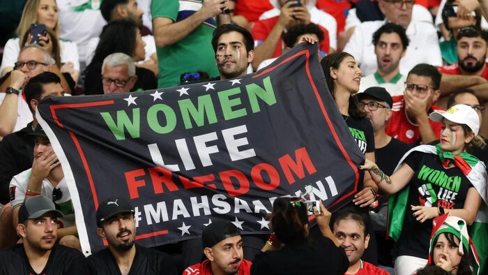 Iran fans hold a banner reading 'Women life freedom' inside the stadium during the match. (Paul Childs/Reuters)