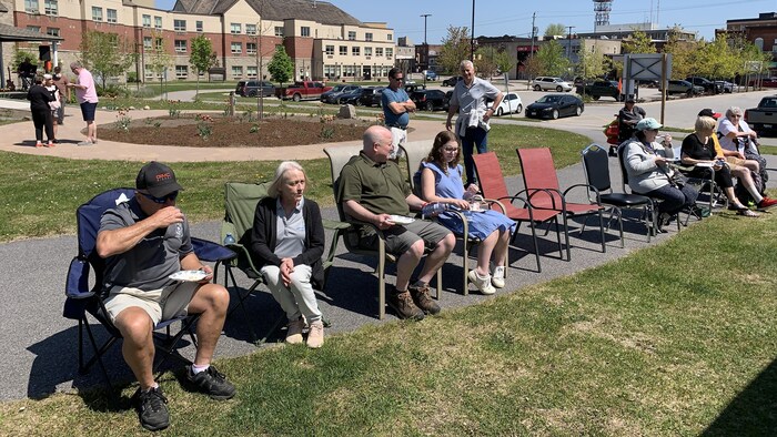 Des personnes assises sur des chaises pliables.