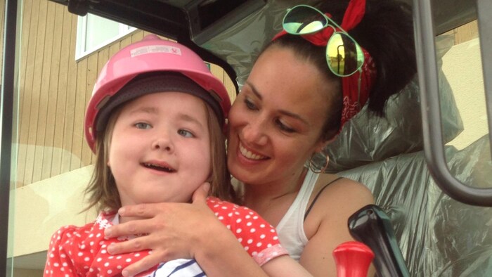 Mélanie Cossette tient dans ses bras sa fille Sofianne, lourdement handicapée