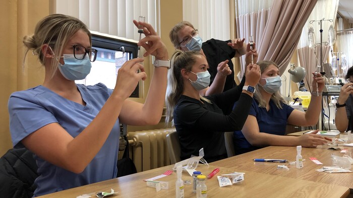 Des étudiantes en soins infirmiers apprennent à utiliser une seringue.