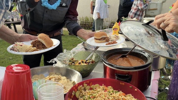  il y a des salades composées, du porc effiloché, et des hot-dogs.