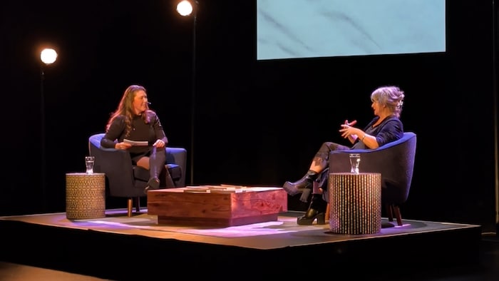 Isabelle Rivest et Guylaine Tremblay assise face à face dans des fauteuils sur la scène de l'Agora des Arts.