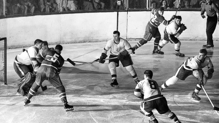 Joueurs en action sur la patinoire dans la zone des Red Wings.