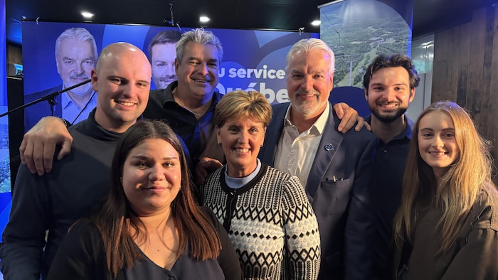Ils sont tous côte à côte, souriants.
