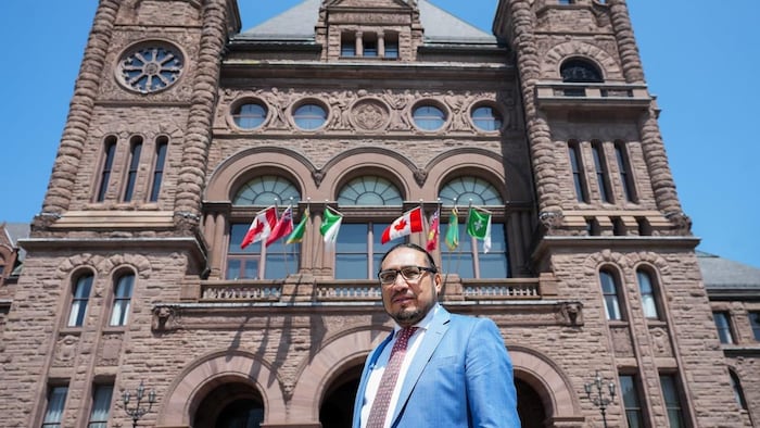 النائب سول ماماكْوا واقفاً أمام مبنى الجمعية التشريعية لمقاطعة أونتاريو في تورونتو.