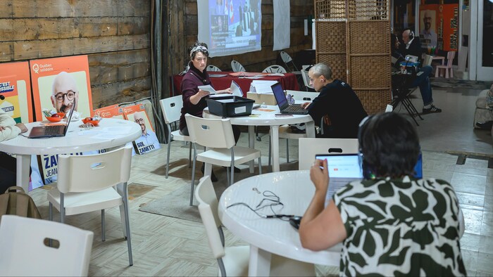Des militants travaillent assis à des tables.