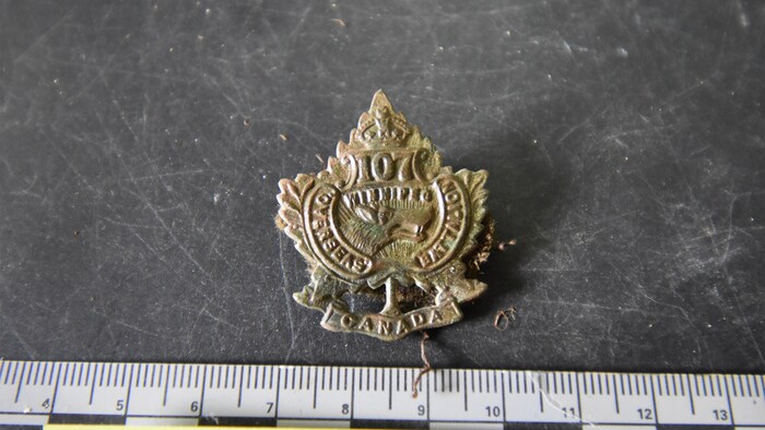 Insigne de casquette du soldat Detmold, l’identifiant comme membre du 107e Bataillon.