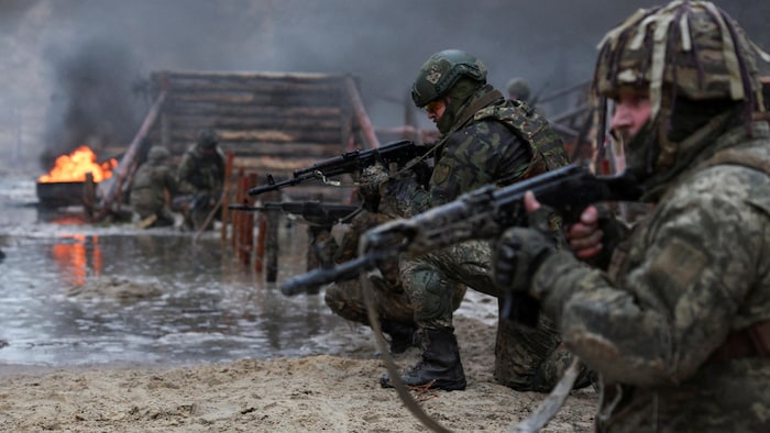 Des soldats ukrainiens en ligne, lourdement armés.