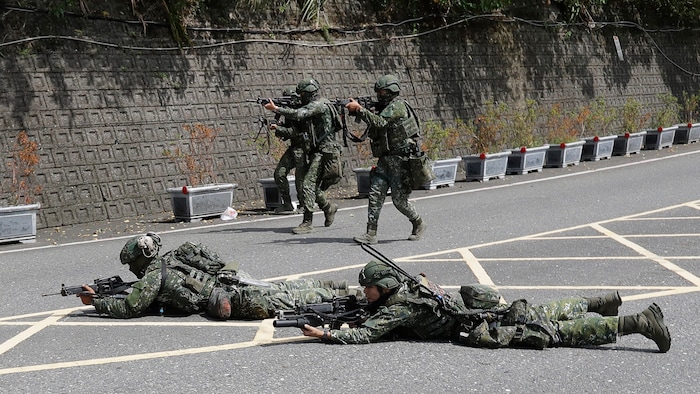 Cinq soldats pointent leur arme sur une cible.