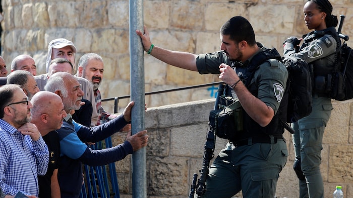 Des soldats israéliens montent la garde alors que des fidèles musulmans attendent d'entrer dans la mosquée Al Aqsa, à Jérusalem.