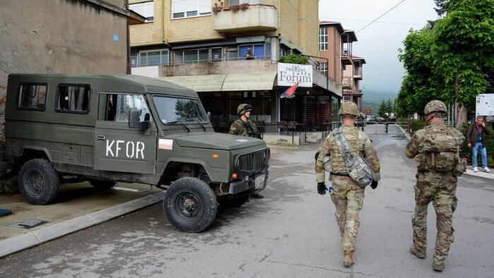 Des soldats marchant dans une rue.