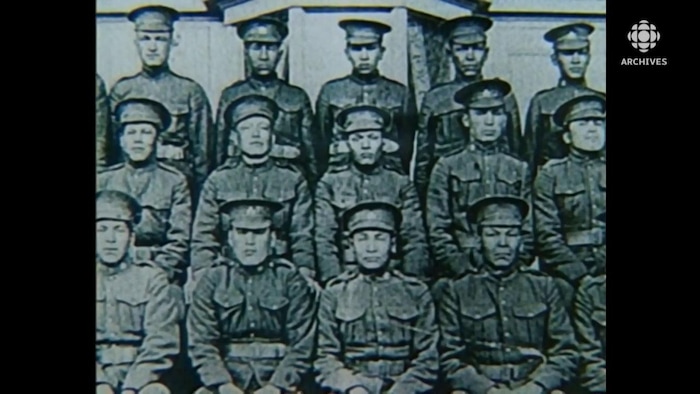 Des militaires autochtones posent en rang dans leur uniformes.