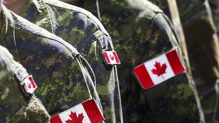 Des soldats canadiens en uniformes de combat. 