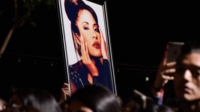 Un fan tient une photo de Selena pendant la cérémonie honorant la chanteuse Selena Quintanilla avec une étoile sur le Hollywood Walk of Fame, le 3 novembre 2017, à Hollywood, en Californie.